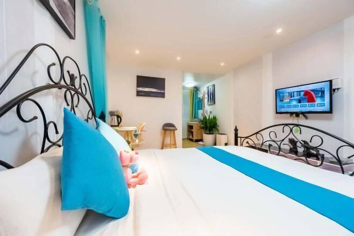 A hotel room with a bed, a television, a desk, and a chair.