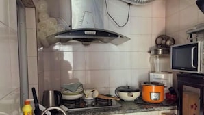 A kitchen with a stove, microwave, and various cooking utensils. - Tongli Ancient Town Forest Journey Design B&B (Suzhou)