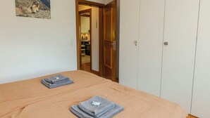 A bedroom with a bed, a wardrobe, and a painting on the wall. - Chalet Anita by Interhome (Zweisimmen)