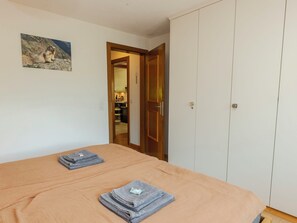 Ein Schlafzimmer mit einem Bett, einem Kleiderschrank und einem Bild an der Wand.