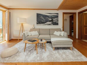 A living room with a sectional sofa, a coffee table, and a floor lamp. - Chalet Anita by Interhome (Zweisimmen)