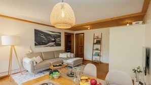 A modern living room with a dining area, a sofa, a coffee table, and a painting on the wall. - Chalet Anita by Interhome (Zweisimmen)