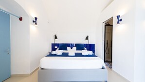 A modern bedroom with a bed, two bedside lamps, and a blue headboard. - MyExclusiveItaly - Elegant Villa in Anacapri | Infinity Pool & Design (Anacapri)