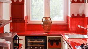 A kitchen with red tiles, a wine cooler, and a large vase. - MyExclusiveItaly - Elegant Villa in Anacapri | Infinity Pool & Design (Anacapri)