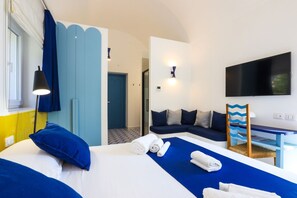 Une chambre d’hôtel avec un lit, un bureau, une télévision et un canapé.
