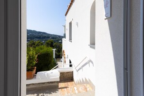A white building with a stone staircase leading to a small outdoor area with a potted plant and a white bench. - MyExclusiveItaly - Elegant Villa in Anacapri | Infinity Pool & Design (Anacapri)