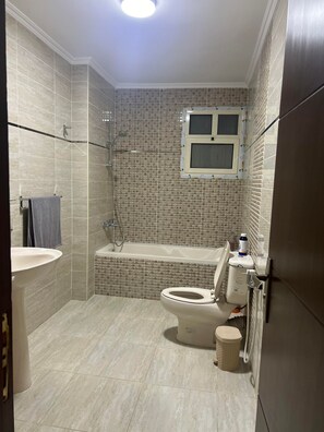 Ein Badezimmer mit Toilette, Bidet und Badewanne.