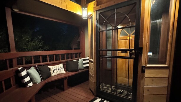 A wooden deck with a bench and a door with a glass panel. - Hot tub, Sauna, adult game room, pool table, house has lots of stairs! (Reno)