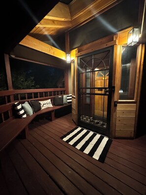 Eine Holzterrasse mit einer Bank und einer Tür mit Fensterteil.