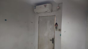 A room with a white door, a ceiling-mounted air conditioner, and a small window with a view of the outside. - OYO Life 93977 Suterejo Homestay Syariah (Surabaya)