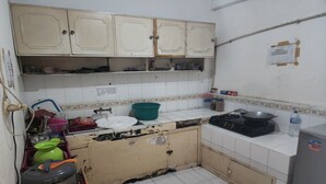 A kitchen with white cabinets, a stove, and various kitchen items. - OYO Life 93977 Suterejo Homestay Syariah (Surabaya)