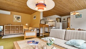 Un salon confortable avec un canapé, une table basse et un coin repas comprenant une table et des chaises.