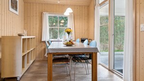 A wooden-paneled room with a dining table, chairs, and a window with curtains. - "Ava" - 850m from the sea by Interhome (Nexø)