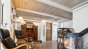 Une pièce chaleureuse avec une cheminée, des fauteuils en cuir et un meuble en bois.