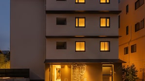 A multi-story hotel with illuminated windows and a map mural on the facade. - hotel anddoggy Kyoto Nijo (Kyoto)