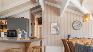 A modern kitchen with wooden accents, a built-in oven, and a bar area with stools. - "Anastaja" - 550m from the sea by Interhome (Jerup)