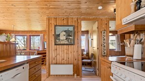Ein Holzblockhaus-Interieur mit Küche, Holzwänden und einem Bild an der Wand.
