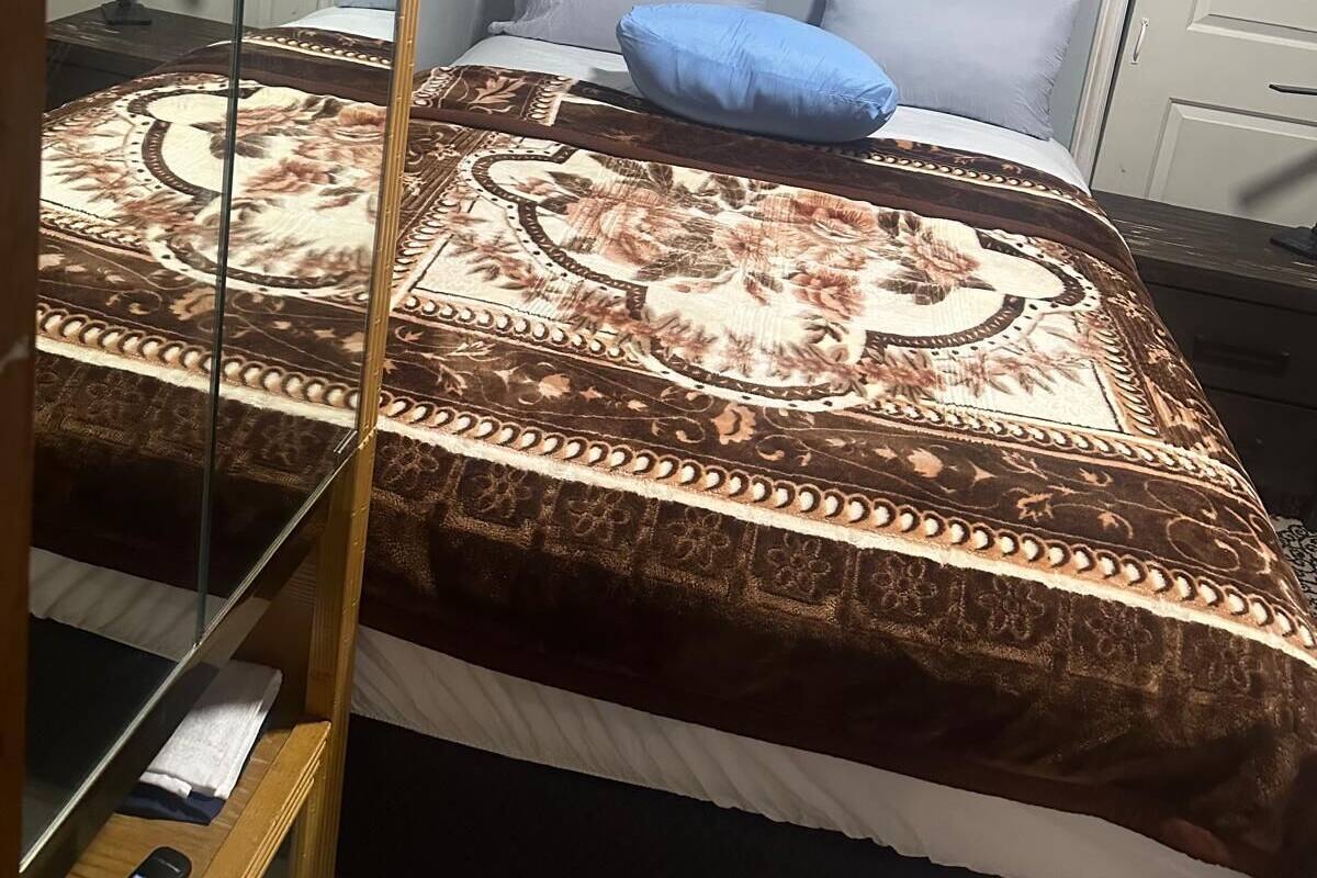 Een slaapkamer met een bed, een spiegel en een deur.