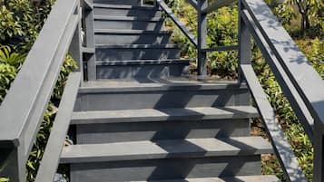 Eine Treppe im Freien mit Geländern, umgeben von viel Grün und Palmen.