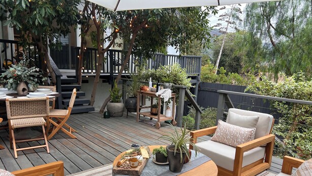 A wooden deck with outdoor furniture, a table with a tray of snacks, and potted plants. - Birds Nest of Topanga - Boho Chic and Minutes from Beach and Topanga Village!! (Topanga)