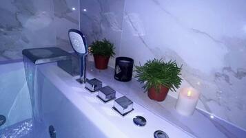 A bathroom with a bathtub, a mirror, and potted plants.