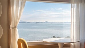 Una habitación con vistas al mar tranquilo, una mesa redonda y una silla.