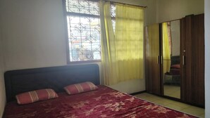 A bedroom with a bed, curtains, and a wardrobe. - OYO Life 93979 Gubeng Homestay Syariah (Surabaya)