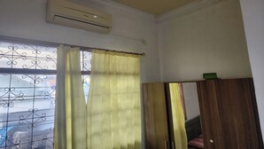 A room with a window, air conditioning unit, and a mirror. - OYO Life 93979 Gubeng Homestay Syariah (Surabaya)