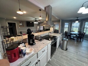 A modern kitchen with granite countertops, a built-in stove, and a large island. - Deluxe House/fitness/ backyard (Monroe)