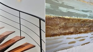 Una escalera con escalones de madera y barandilla metálica.