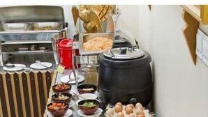 A buffet table with various dishes and utensils. - My Hotel Myanmar (Yangon)