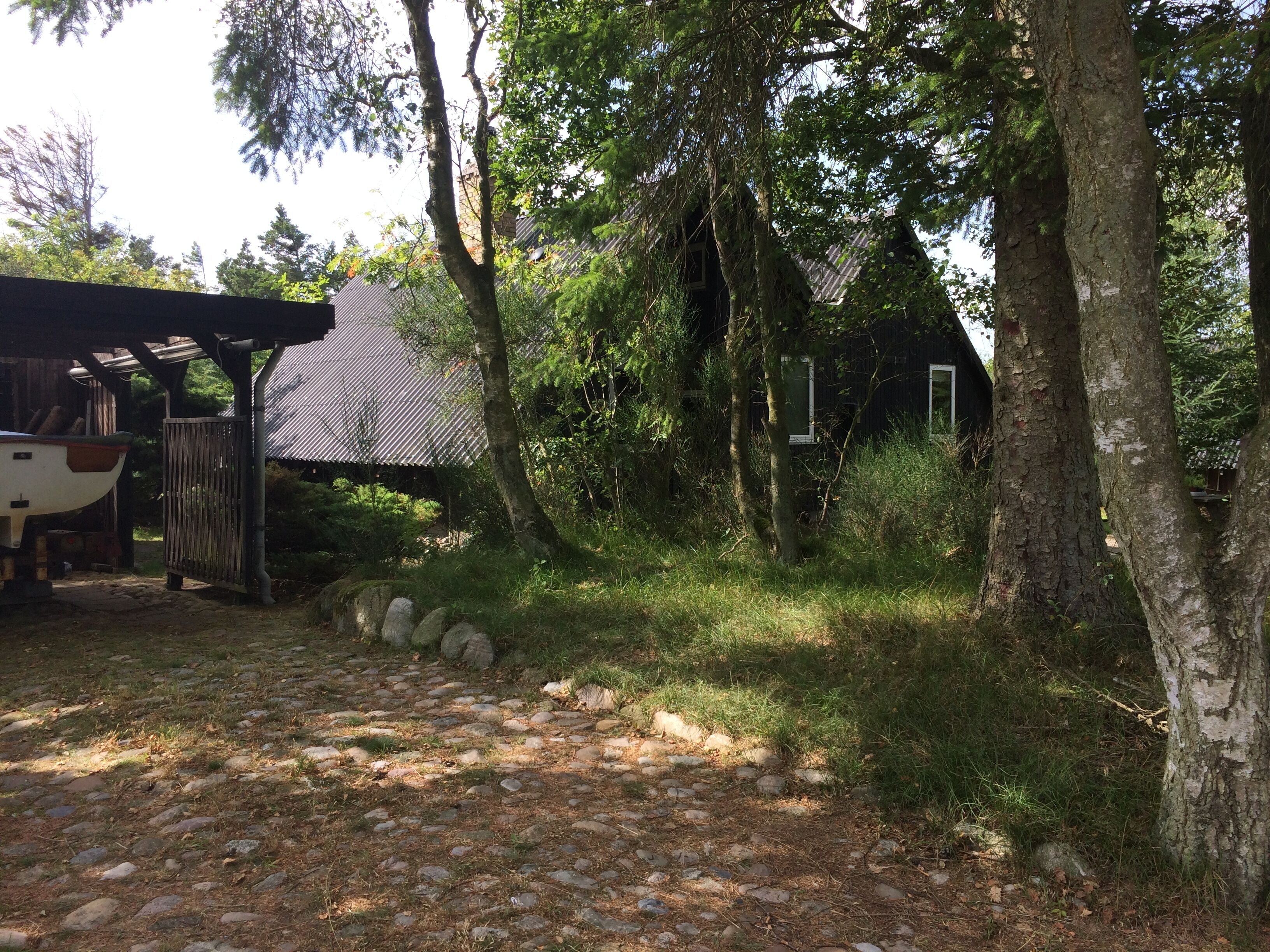A rustic cabin with a stone pathway leading to a wooden dock.
