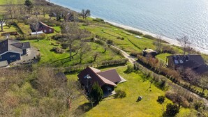 Een kustbezit met meerdere huizen, een gazon en uitzicht op zee.