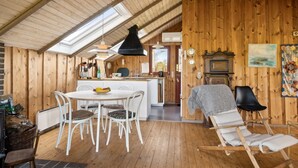 Een gezellig houten interieur met een eethoek, een keuken en een zithoek.