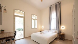 Une chambre à coucher avec un lit, des tables de chevet, un bureau et une chaise.