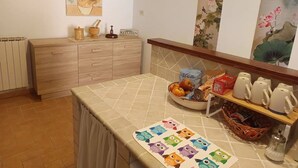 A kitchen with a wooden cabinet, a tiled backsplash, and various kitchen items on the counter. - Accogliente Appartamento, Animali Ammessi, Vicino Roma, Bracciano, Ladispoli (Lazio)