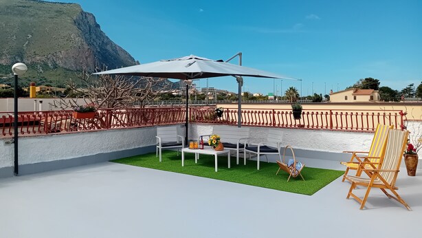 A rooftop terrace with a white table and chairs, a hanging chair, and a large umbrella. - Relax in Style:Spacious 4-Bedroom Villa Rosetta Near Palermo's Coastal Treasures (Carini)