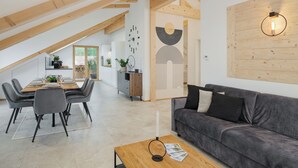 Ein modernes Interieur mit Essbereich, einer Couch und einer Holzzieldecke.