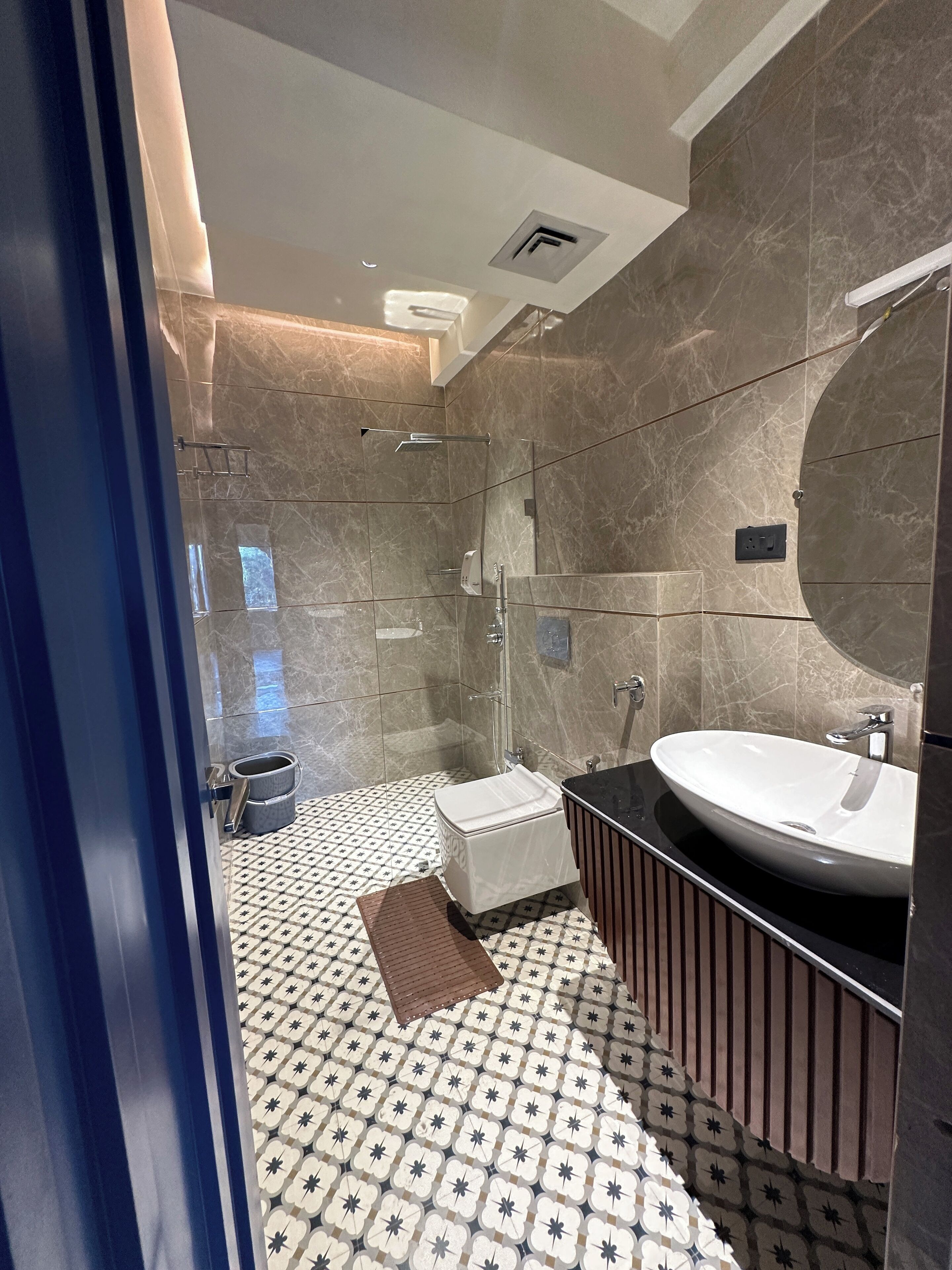 Un baño moderno con un espejo grande, un lavabo y una zona de ducha.