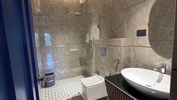 Un baño moderno con un espejo grande, un lavabo y una zona de ducha.