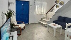 A living room with a blue door, white walls, a staircase, and a ceiling fan. - Casa Blue in Torrox With 2 Bedrooms and 1 Bathrooms (Torrox)