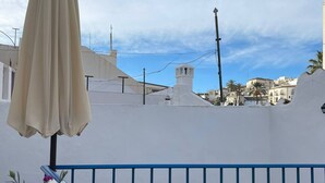 A rooftop terrace with a table set for dining, a potted plant, and a beige umbrella. - Casa Blue in Torrox With 2 Bedrooms and 1 Bathrooms (Torrox)