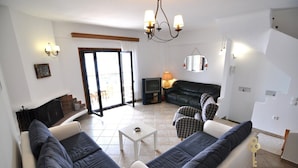 Ein Wohnzimmer mit einer Sofagarnitur, einem Fernseher, einem Kamin und einem Essbereich.