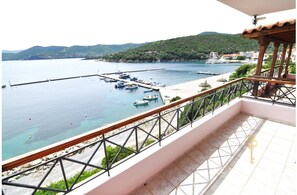 A balcony with a view of a marina and a hilly landscape. - Zennova 43 Pirgadikia Sky & Sea Home (Aristotelis)