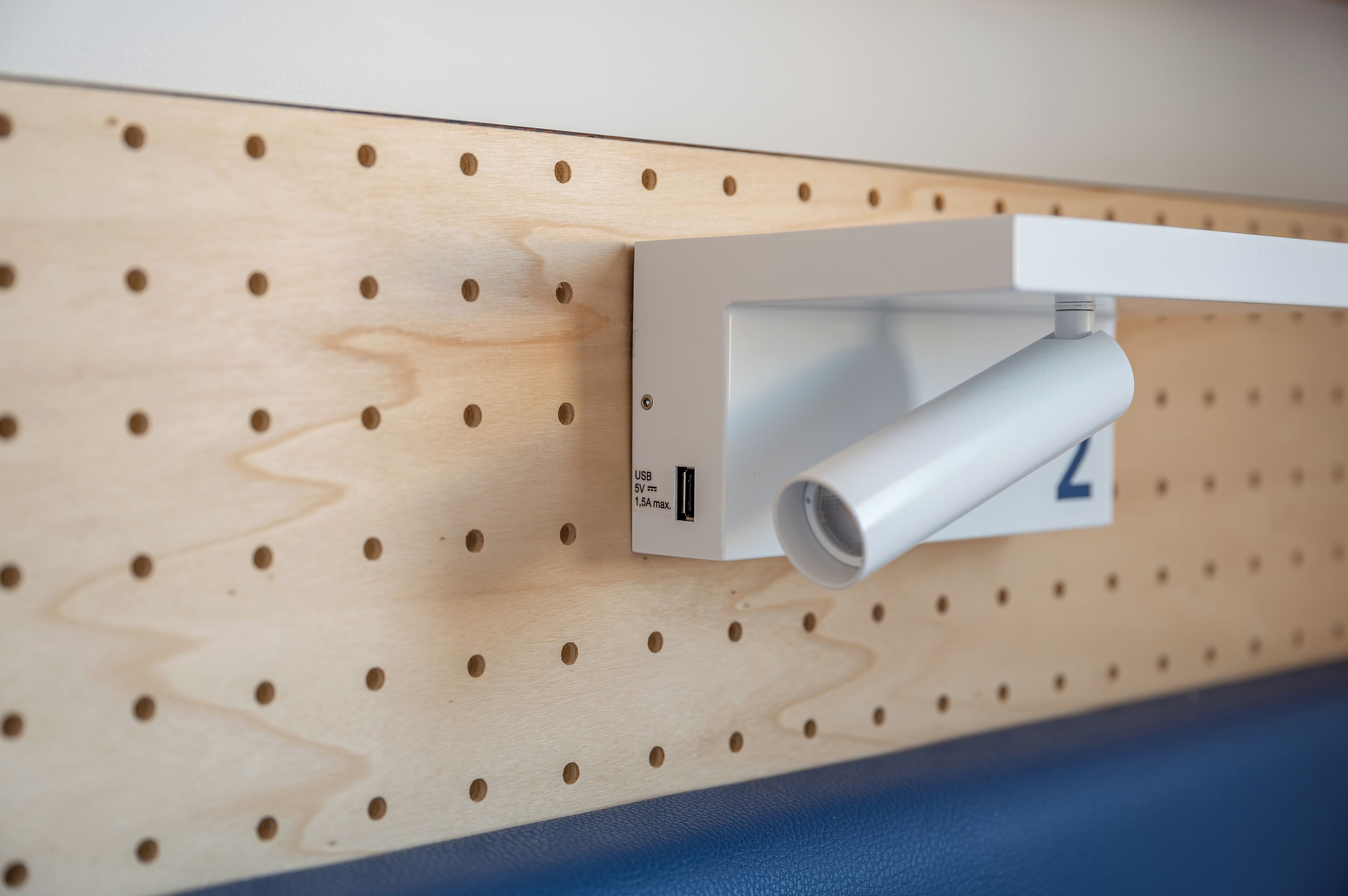 Dispositivo montado en la pared con un puerto USB y una etiqueta que indica una corriente máxima de 1.5A.