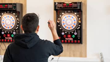 A person playing darts at a dartboard.