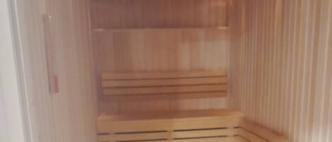 Un sauna avec des bancs en bois et un sol carrelé.
