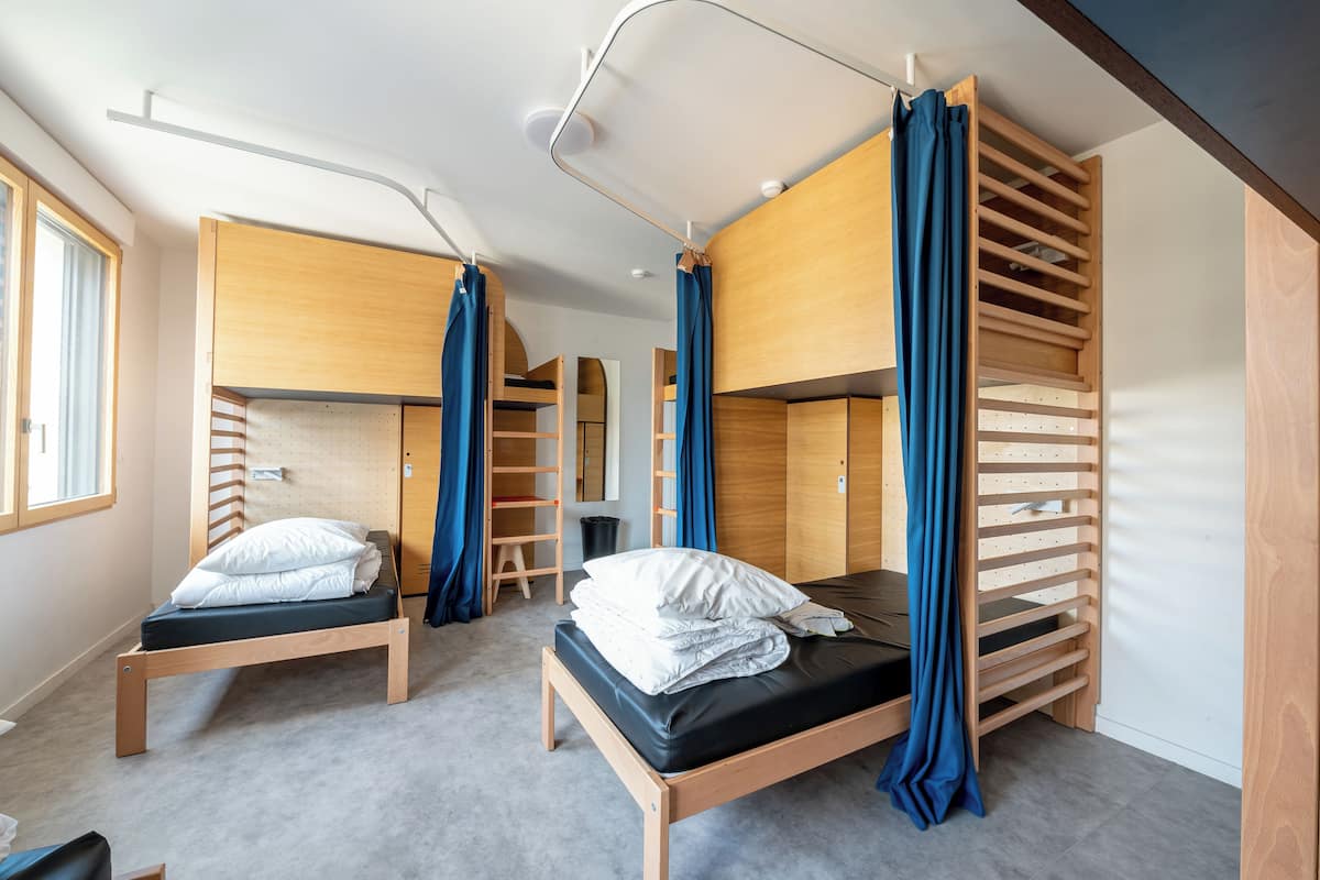 Ein Zimmer mit Etagenbetten, einem Schreibtisch und einem Stuhl.
