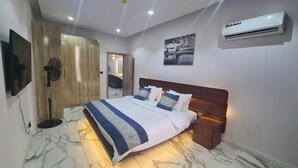 A bedroom with a bed, bedside table, and an air conditioning unit. - Luxury 3 bedroom, Secure, Water View, 24/7 Power in secluded estate - Ikoyi  (Lagos)
