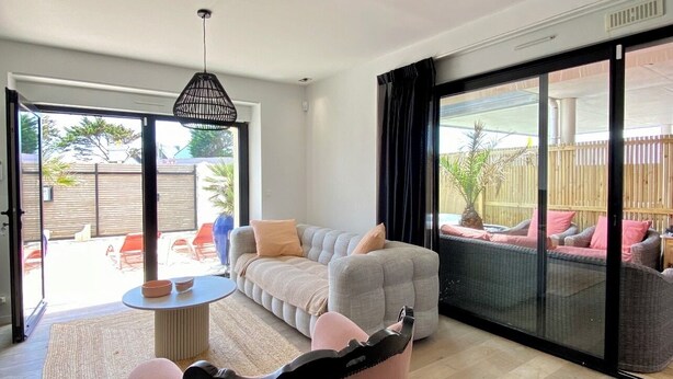 A spacious living room with a large sliding glass door leading to an outdoor area. - Apartment TY COSY in front of the beach of the blocked fort, calm and serenity.  (Ploemeur)
